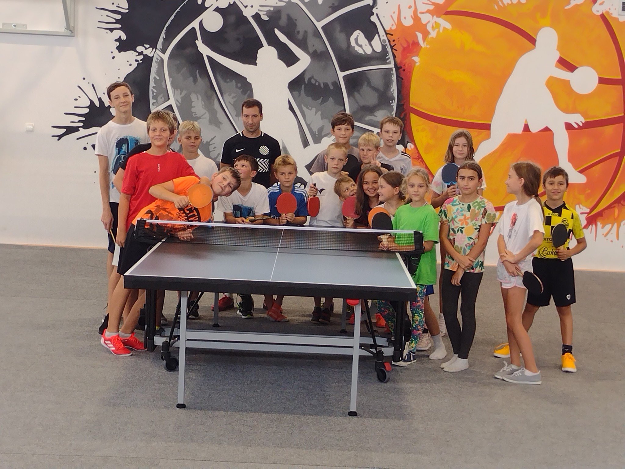 Dzieci stojące przy stole do ping-ponga