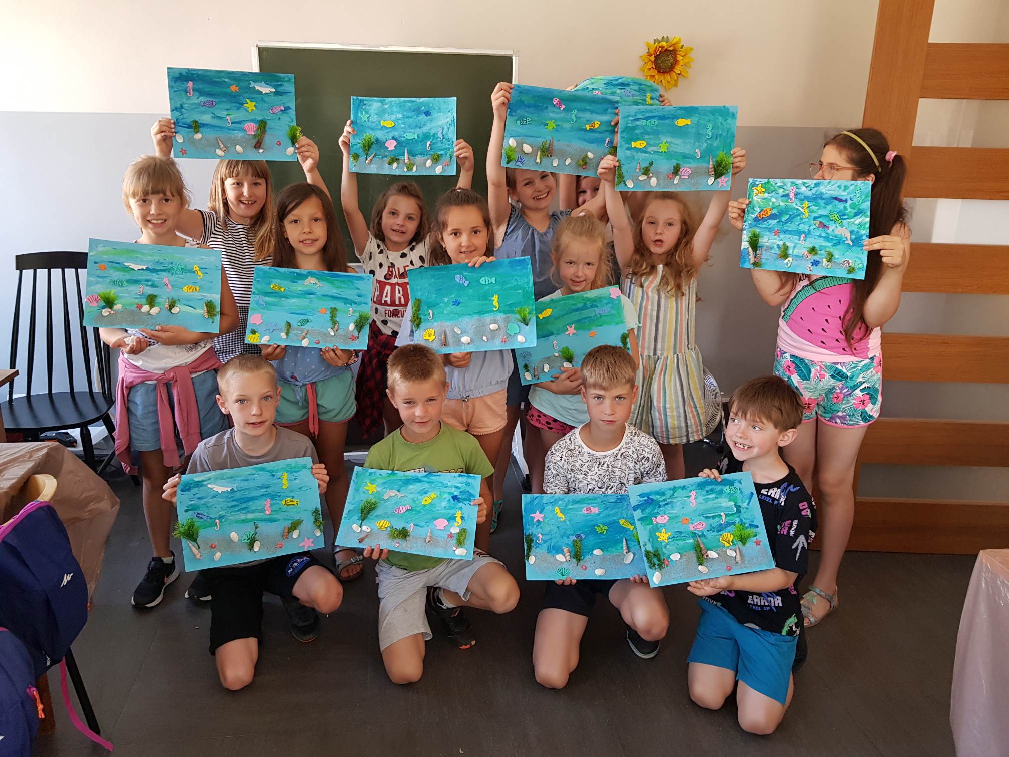 Dzieci pokazujące swoje prace malarskie
