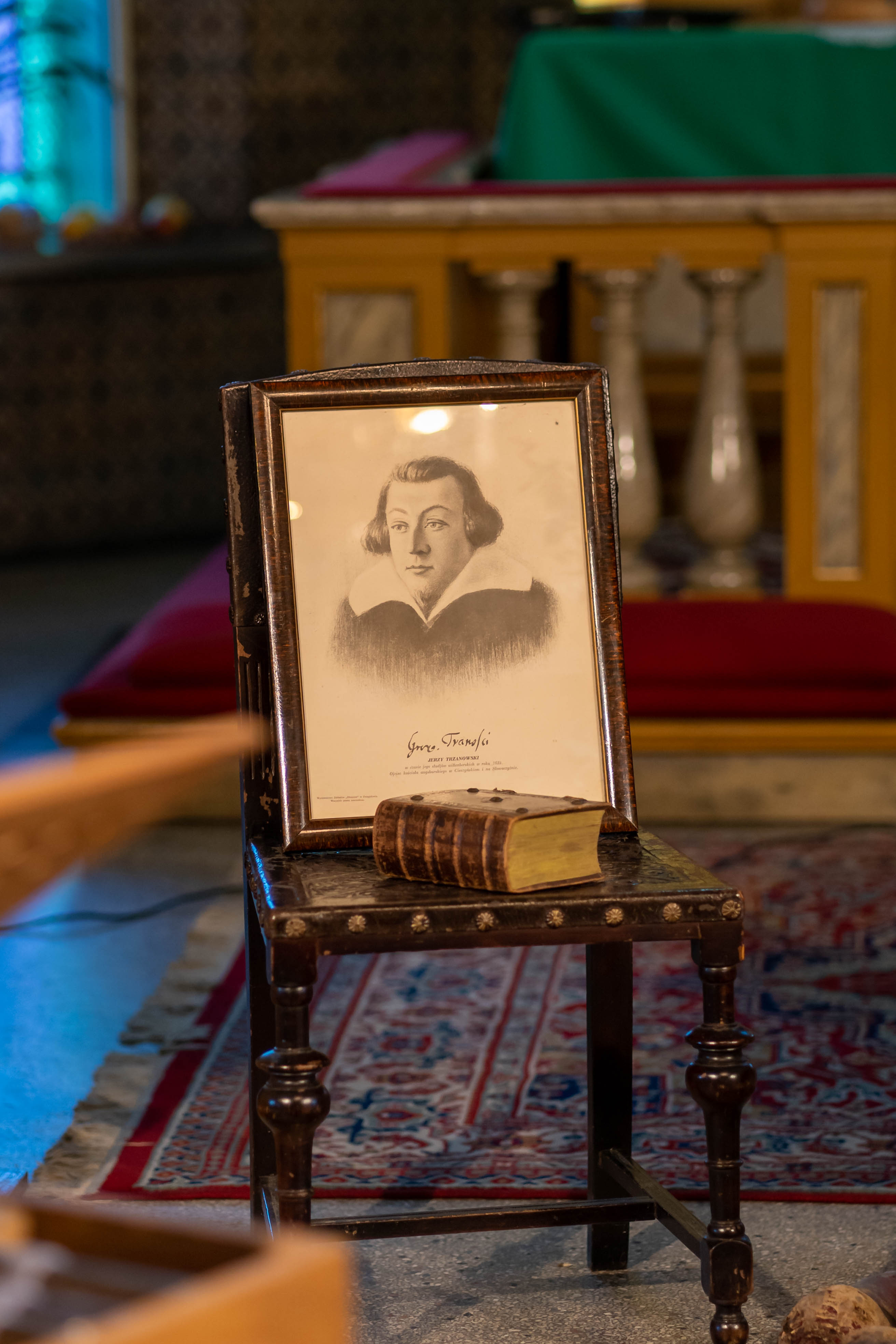 Stare zdjęcie mężczyzny stoi na krześle obok księgi